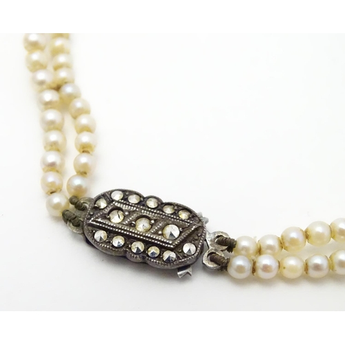 472 - A double strand pearl necklace  / choker of graduated pearls with silver and marcasite clasp. approx... 