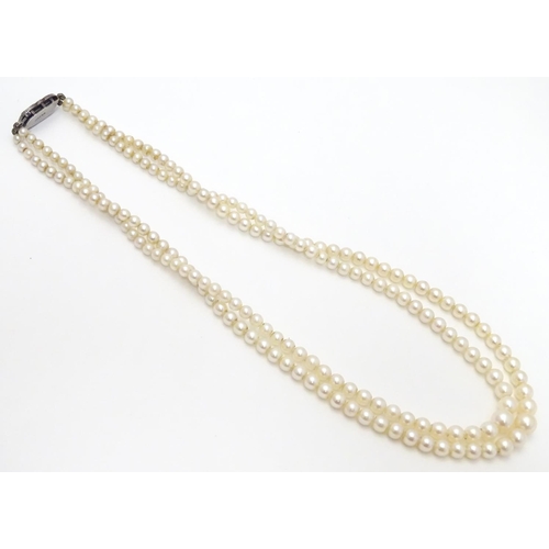 472 - A double strand pearl necklace  / choker of graduated pearls with silver and marcasite clasp. approx... 