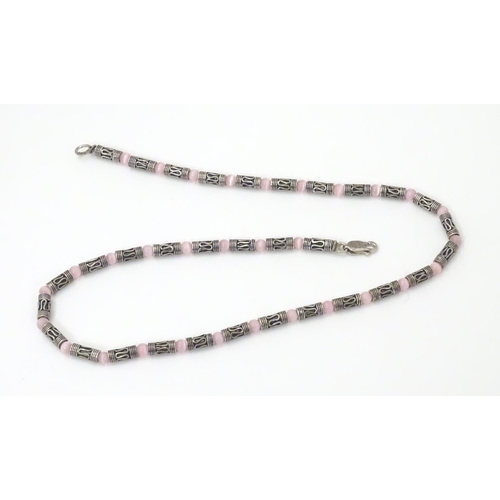 535 - A silver and white metal necklace set with pink cats eye beads. Approx 16'' long