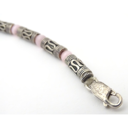 535 - A silver and white metal necklace set with pink cats eye beads. Approx 16'' long