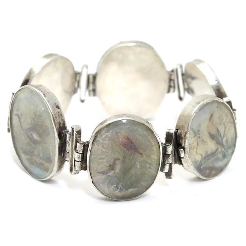 536 - A Victorian white metal bracelet set with 6 locket roundels containing hand painted  studies of bird... 