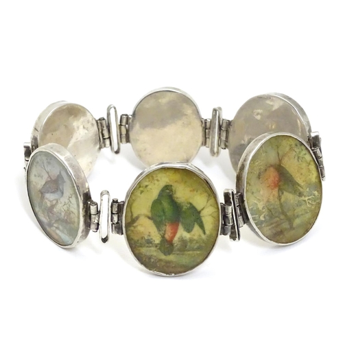 536 - A Victorian white metal bracelet set with 6 locket roundels containing hand painted  studies of bird... 