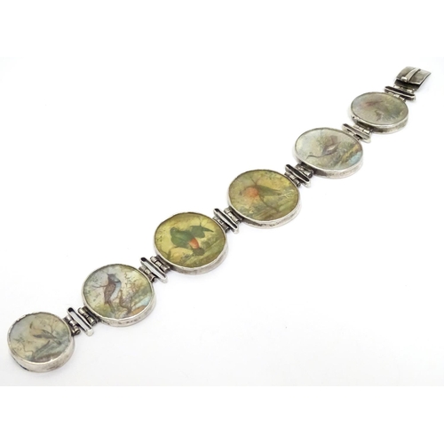 536 - A Victorian white metal bracelet set with 6 locket roundels containing hand painted  studies of bird... 