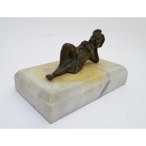 818 - A 20thC paperweight of rectangular form, decorated with a cast model of a reclining woman on a marbl... 