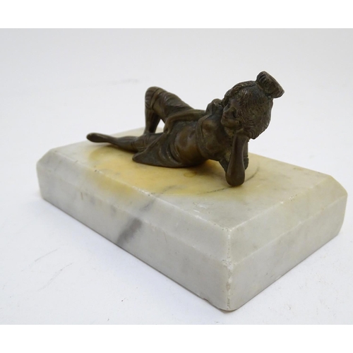 818 - A 20thC paperweight of rectangular form, decorated with a cast model of a reclining woman on a marbl... 