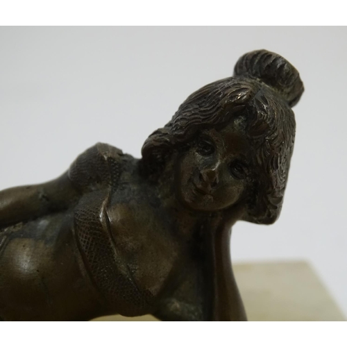 818 - A 20thC paperweight of rectangular form, decorated with a cast model of a reclining woman on a marbl... 