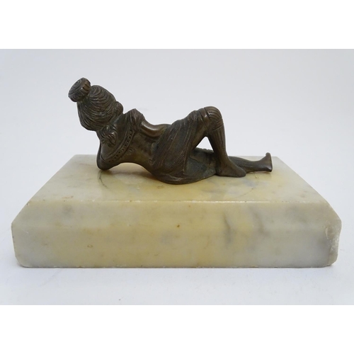 818 - A 20thC paperweight of rectangular form, decorated with a cast model of a reclining woman on a marbl... 