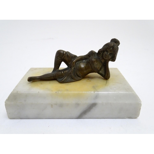 818 - A 20thC paperweight of rectangular form, decorated with a cast model of a reclining woman on a marbl... 