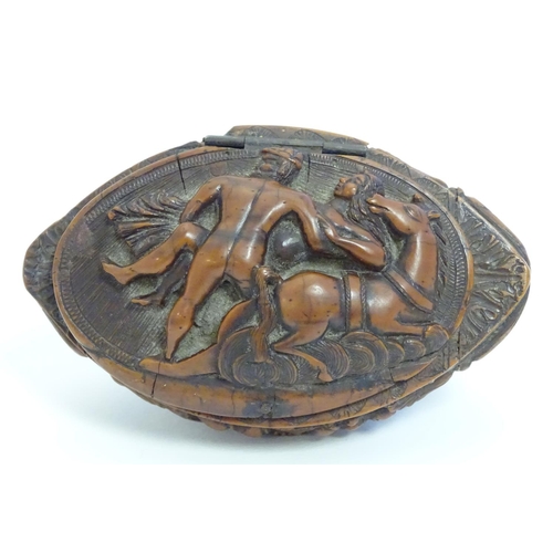 837 - A Continental carved nut snuff box, the hinged lid decorated with a horse and a man carrying a woman... 