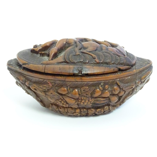 837 - A Continental carved nut snuff box, the hinged lid decorated with a horse and a man carrying a woman... 