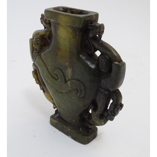 851 - An Oriental soapstone vase of baluster form with stylised figural and animal twin handles. Approx. 4... 