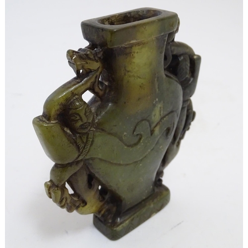 851 - An Oriental soapstone vase of baluster form with stylised figural and animal twin handles. Approx. 4... 