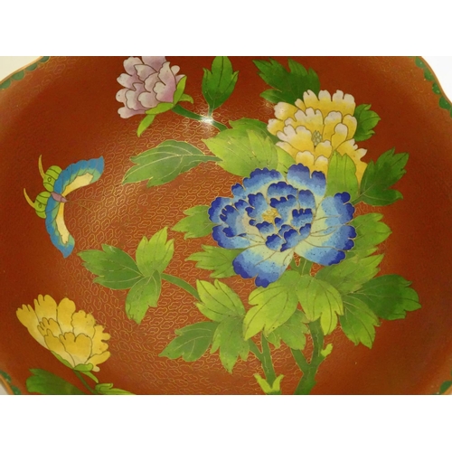 852 - A Chinese cloisonne ware bowl with a lobed rim, decorated with flowers and butterflies, on a carved ... 