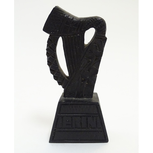 891 - A 19thC Irish bog oak carved harp with shamrock decoration on a tapering base inscribed Erin. Approx... 