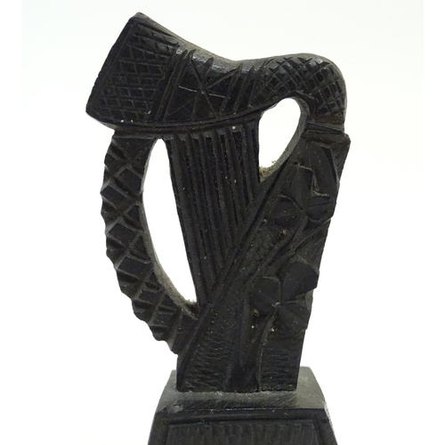 891 - A 19thC Irish bog oak carved harp with shamrock decoration on a tapering base inscribed Erin. Approx... 