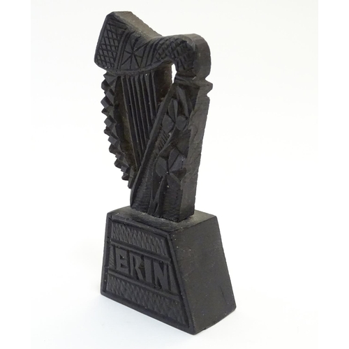 891 - A 19thC Irish bog oak carved harp with shamrock decoration on a tapering base inscribed Erin. Approx... 