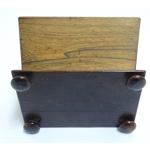 894 - A 19thC rosewood pin cushion of sarcophagus form with four bun feet. Approx. 4 1/4