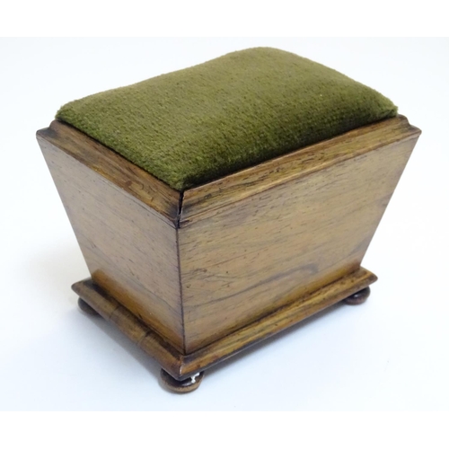 894 - A 19thC rosewood pin cushion of sarcophagus form with four bun feet. Approx. 4 1/4