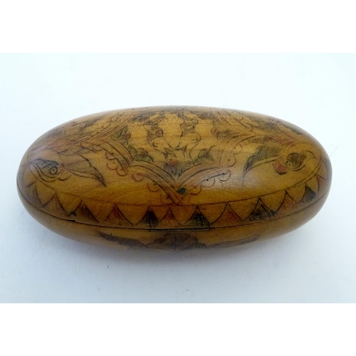 913 - A 19thC Scandinavian treen snuff box of oval form with naive penwork decoration depicting stylised f... 