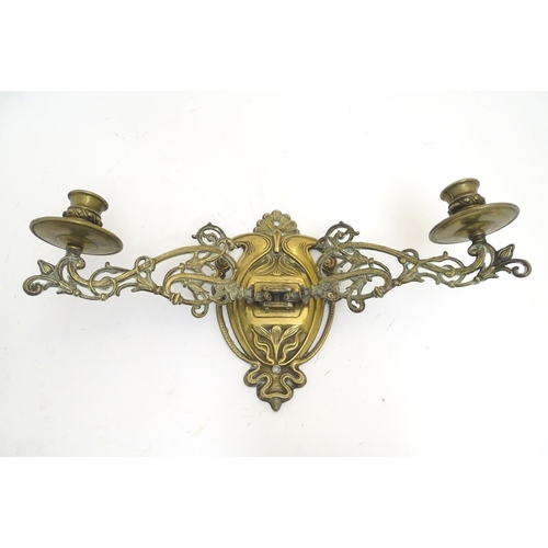 945 - A trio of 19thC brass adjustable double wall sconces, decorated with acanthus fronds and elements of... 