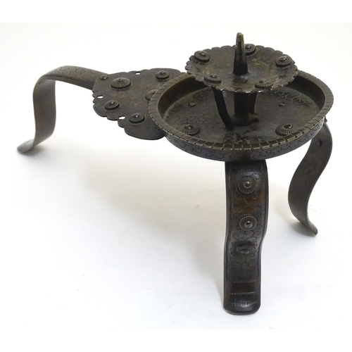 1001 - A Japanese bronze candle stand with a raised sconce, on three supports, with scrolling punchwork dec... 