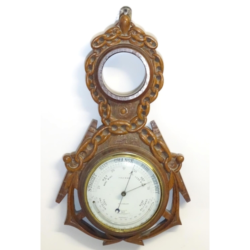 1196 - A Victorian aneroid barometer by Field & Son, Aylesbury, the carved oak case decorated with naval mo... 