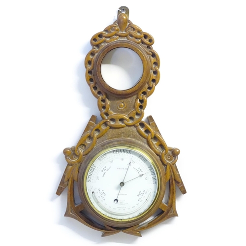 1196 - A Victorian aneroid barometer by Field & Son, Aylesbury, the carved oak case decorated with naval mo... 