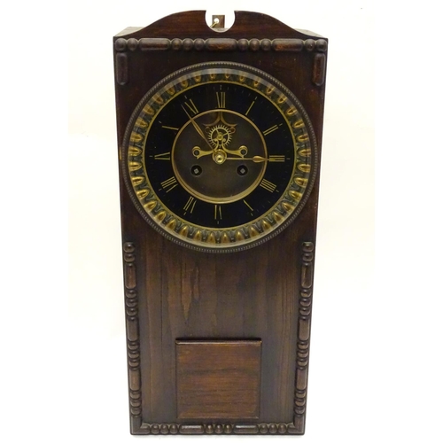 1197A - An Edwardian wall clock, the stained oak case housing a black and gilt numeral dial, 17 3/4