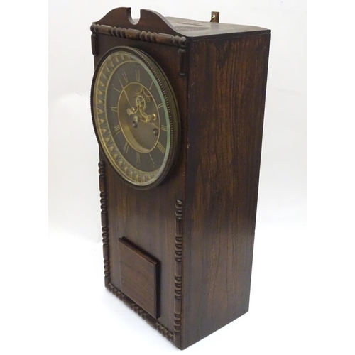 1197A - An Edwardian wall clock, the stained oak case housing a black and gilt numeral dial, 17 3/4