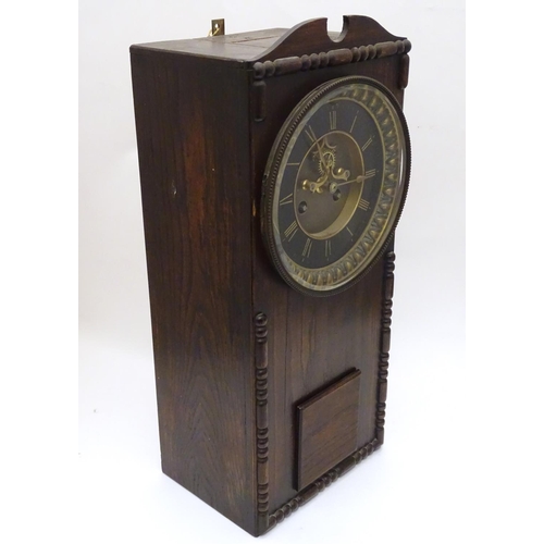 1197A - An Edwardian wall clock, the stained oak case housing a black and gilt numeral dial, 17 3/4