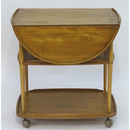 1236 - Vintage Retro, Mid-Century: an Ercol elm and beech three tiered trolley, the top with drop flaps, su... 