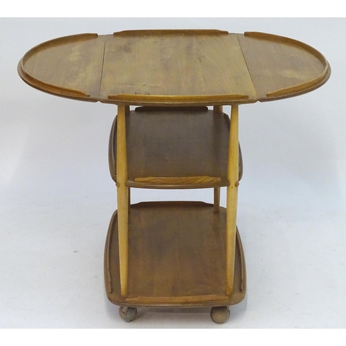 1236 - Vintage Retro, Mid-Century: an Ercol elm and beech three tiered trolley, the top with drop flaps, su... 