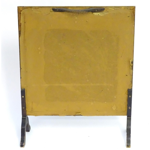 1036 - A 20thC fire screen with a moulded surround above a glazed needlework centre. 22