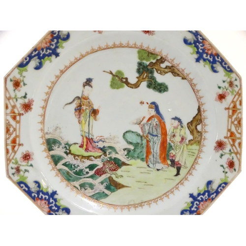 12 - A Chinese plate of octagonal form decorated in famille rose depicting figures in a coastal landscape... 