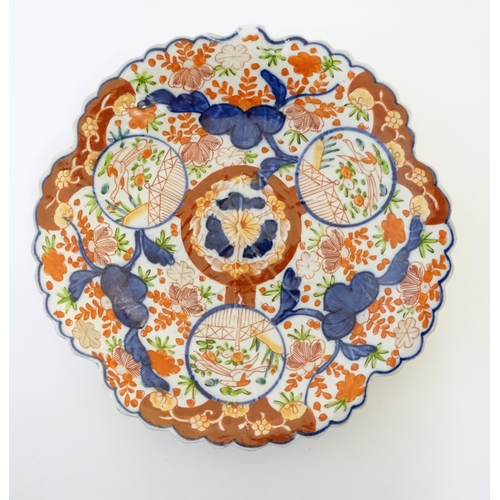 18 - A Japanese Imari plate with a scalloped rim with stylised leaf veins in relief to the centre, decora... 