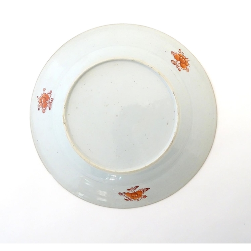 19 - A Chinese plate with central floral and foliate detail, with a patterned border with flowers and sty... 