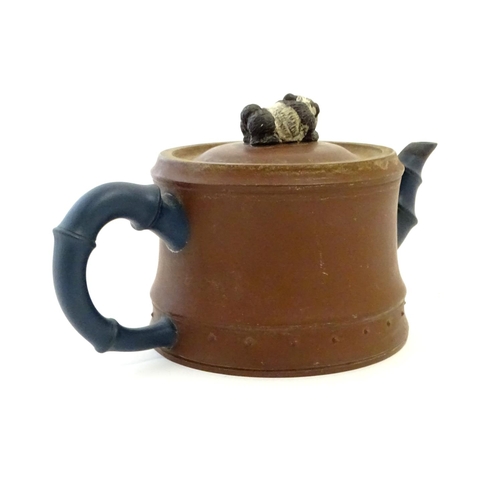 39 - A Chinese clay teapot, the handle and spout modelled as stylised bamboo, the lid surmounted by a rec... 