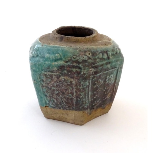 44 - A Chinese hexagonal Shiwan ginger jar / vase with moulded floral and foliate detail with a blue / gr... 
