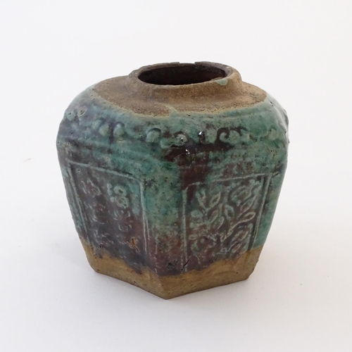 44 - A Chinese hexagonal Shiwan ginger jar / vase with moulded floral and foliate detail with a blue / gr... 
