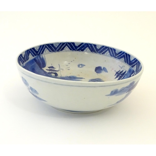 9 - A Chinese blue and white bowl with hand painted decoration depicting an Oriental landscape with pago... 