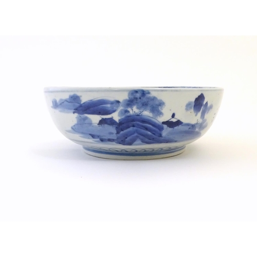 9 - A Chinese blue and white bowl with hand painted decoration depicting an Oriental landscape with pago... 