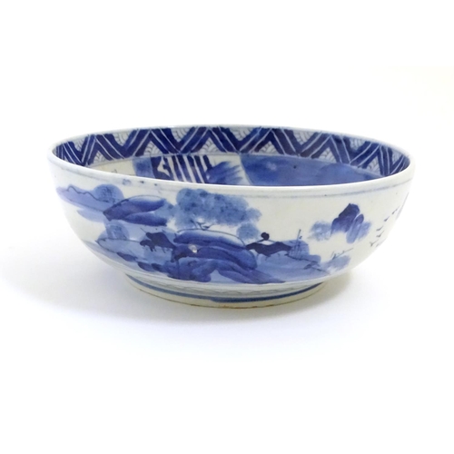 9 - A Chinese blue and white bowl with hand painted decoration depicting an Oriental landscape with pago... 