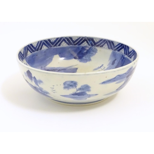 9 - A Chinese blue and white bowl with hand painted decoration depicting an Oriental landscape with pago... 