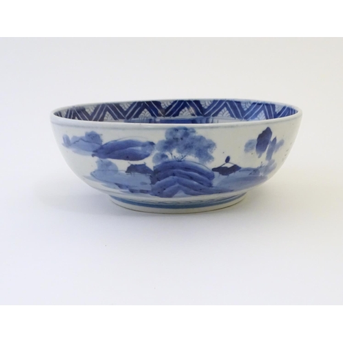 9 - A Chinese blue and white bowl with hand painted decoration depicting an Oriental landscape with pago... 