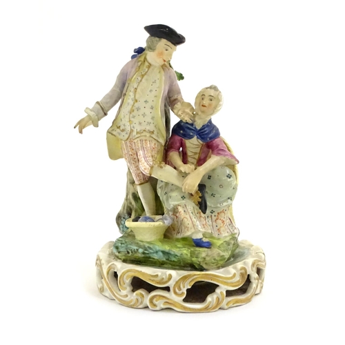 76 - A Continental porcelain figural group depicting a shoe shine girl shining a gentleman's shoes in a n... 