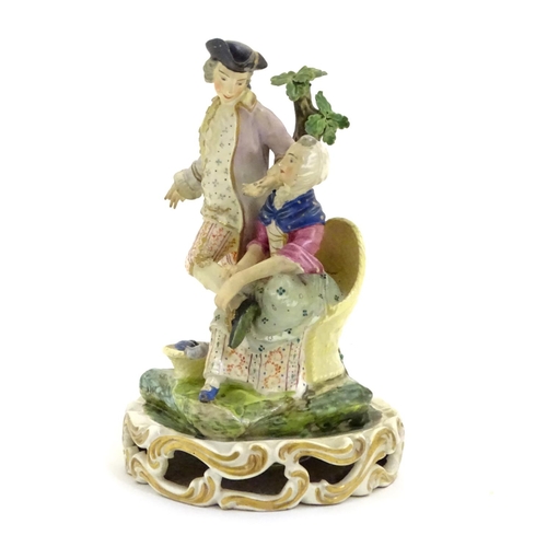 76 - A Continental porcelain figural group depicting a shoe shine girl shining a gentleman's shoes in a n... 