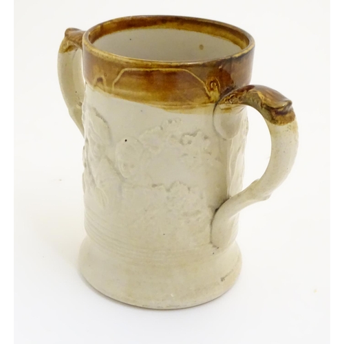 94 - A 19thC two tone stoneware loving cup tankard, the body moulded in relief with tavern scenes with Im... 