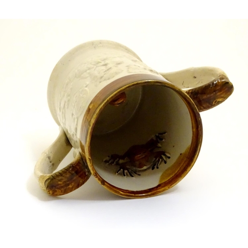 94 - A 19thC two tone stoneware loving cup tankard, the body moulded in relief with tavern scenes with Im... 