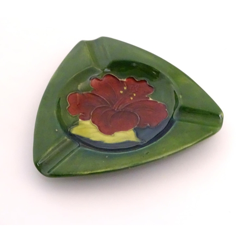 111 - A Moorcroft green ground pin dish / ashtray of triangular form in the Hibiscus pattern. Impressed ma... 