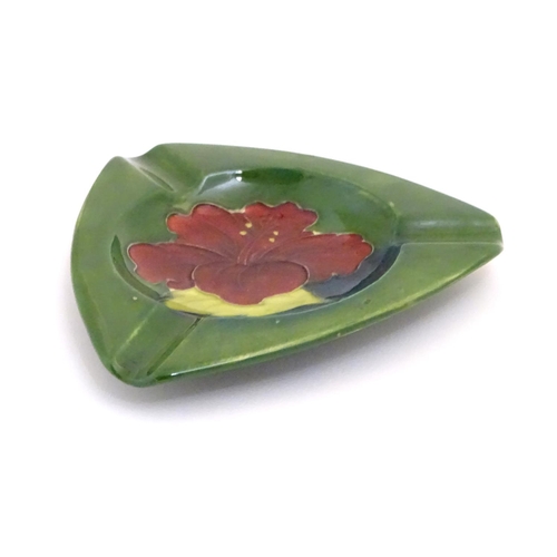 111 - A Moorcroft green ground pin dish / ashtray of triangular form in the Hibiscus pattern. Impressed ma... 